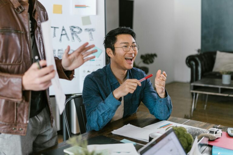 man sitting at a desk smiling and collaborating